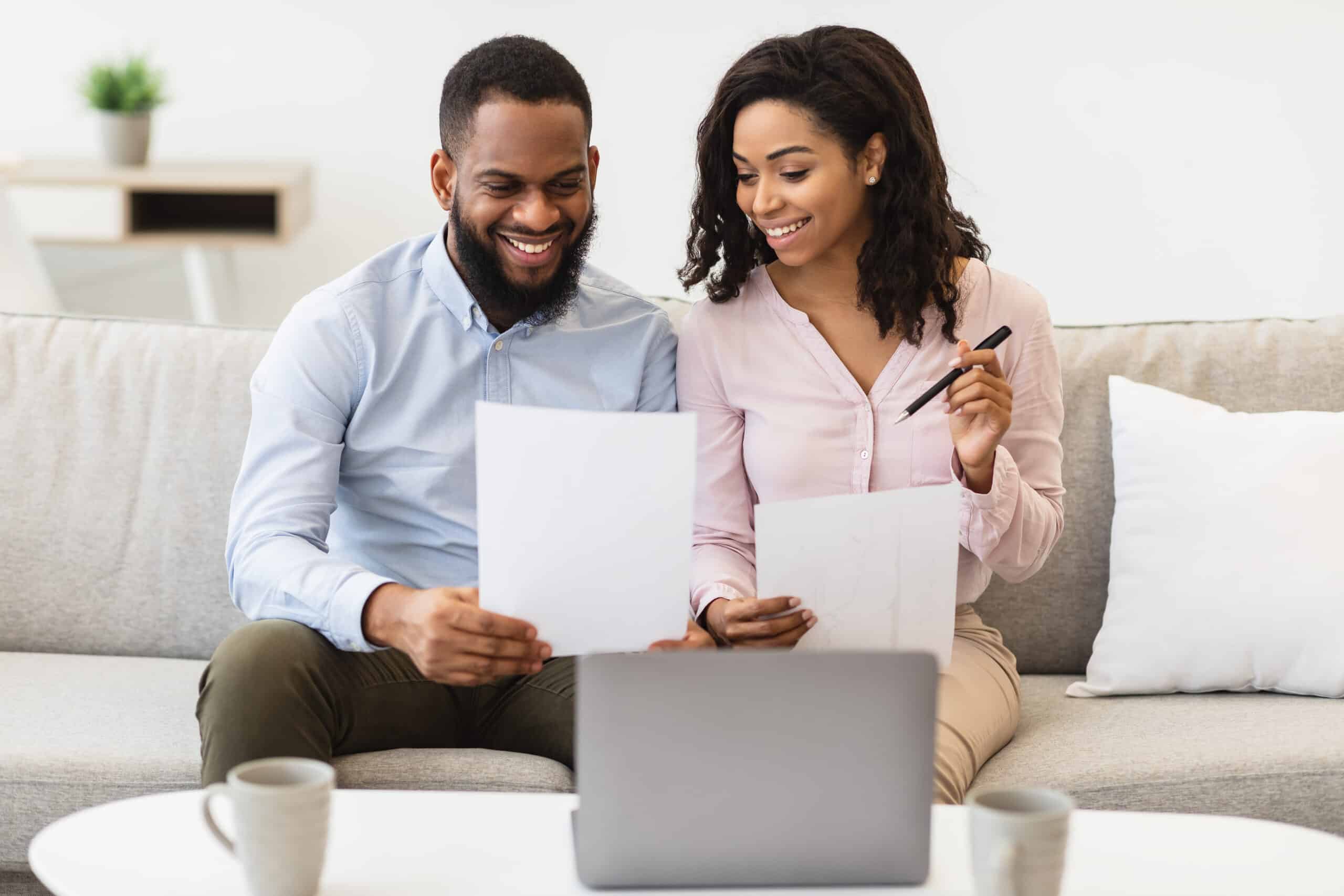 Joyful Black couple immersed in a shared moment of love and connection while enjoying a book together.